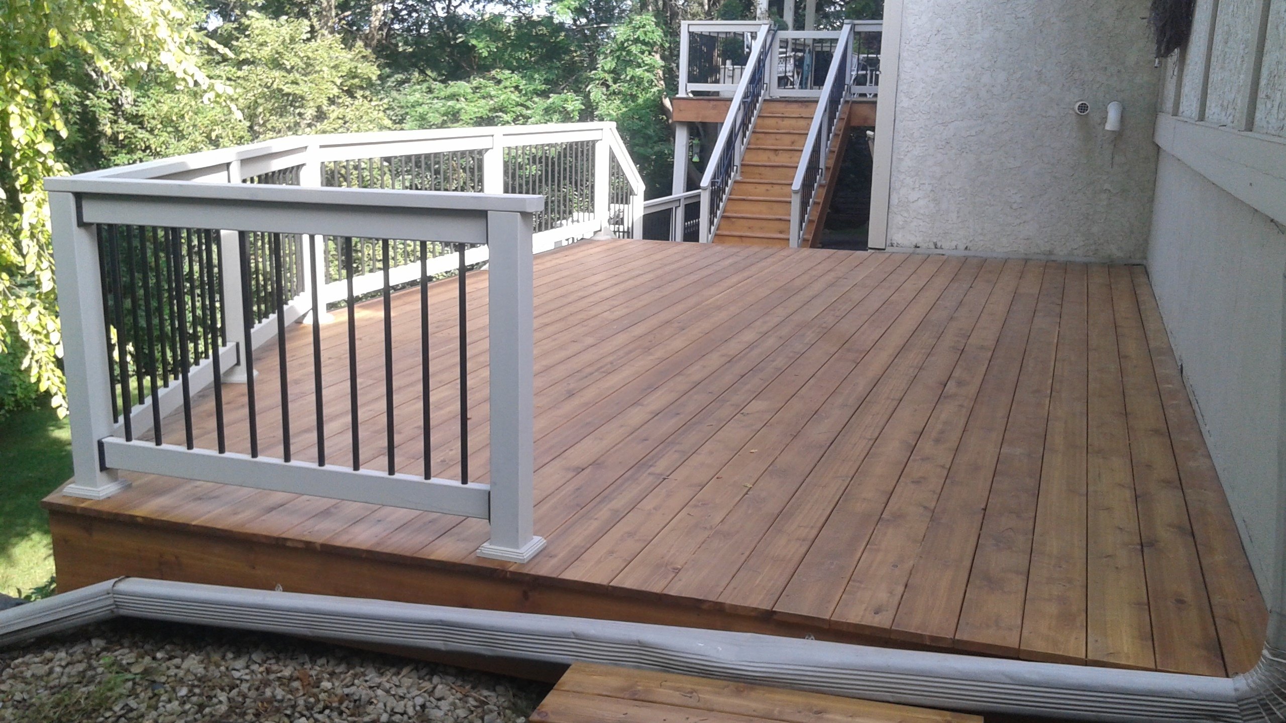 Custom cedar deck built by Minnesota carpentry company with black and white railings.