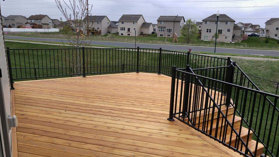 Custom wood deck installation with elegant railings, designed for outdoor living space and relaxation.