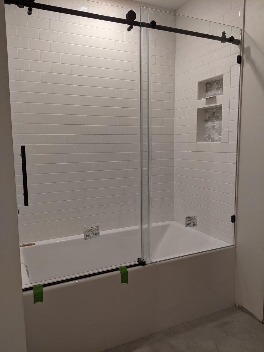 Modern shower remodel with sleek tile work, glass door, and contemporary fixtures in a stylish bathroom.